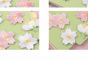 Macro shot of self-adhesive cherry blossom embroidery patches in white and pink color