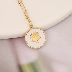 Macro view of gold stainless steel necklace with round white shell rose pendant