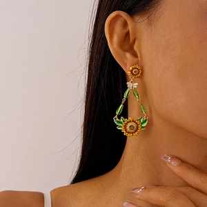 Detail shot of long sunflower bee earrings with green bead triangle frame work