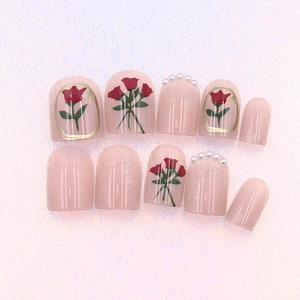 Short oval press-on nails in pale pink with red rose art and white pearl accents