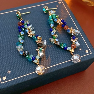 Detailed close-up of vintage tassel earrings with multi-color crystal beads on gift box