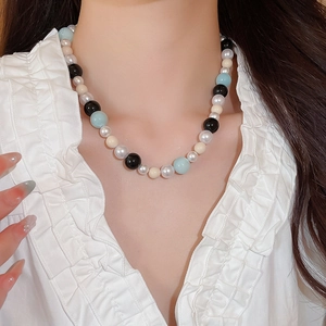Detail of colorful beads and pearls on the necklace worn by a model in a close-up