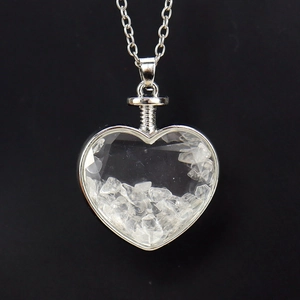 Detail view of heart-shaped glass pendant with white crystal gravel and silver chain