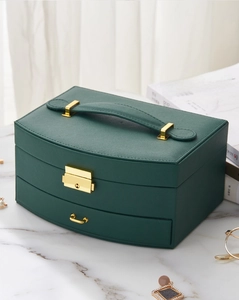 Detailed view of dark green leather jewelry box with golden lock and top handle