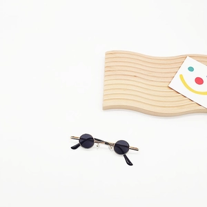 Mini vintage round sunglasses with gold metal frame and dark lenses on a white background