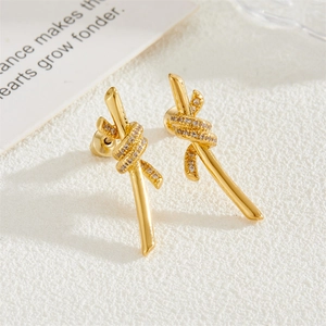 Elegant gold knot stud earrings featuring sparkling white zircon pave on white card background