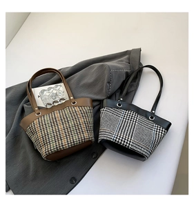 Close-up of contrast checkered canvas bucket bag on a grey blazer showing material detail