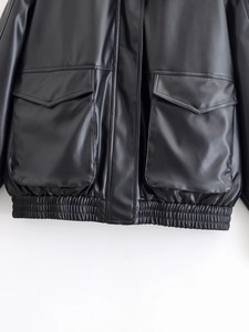Close-up of black PU leather jacket featuring large flap pockets and elastic hem details