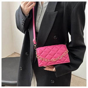 Close-up of pink quilted crossbody bag featuring a gold chain strap and PU leather finish