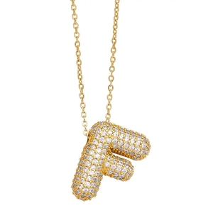 Macro view of gold letter F pendant with sparkling white cubic zirconia stones