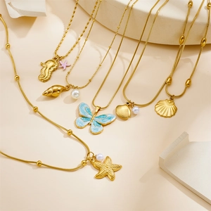 Gold ocean themed necklaces featuring starfish shells and blue enamel butterflies pendants