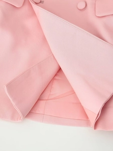Detail of pink blazer fabric showing twill texture and high-quality stitching finish