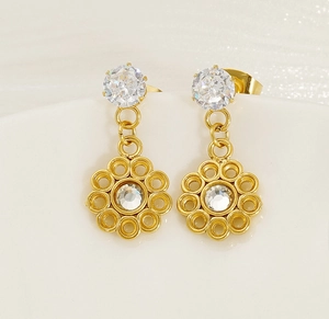Macro shot of gold floral drop earrings featuring clear zircons and hollow petal design