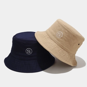 Detail of embroidered 'S' logo on navy and beige cotton canvas bucket hats