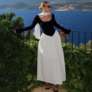 Detail of elegant black and white color-block maxi dress set with scarf on blue ocean background