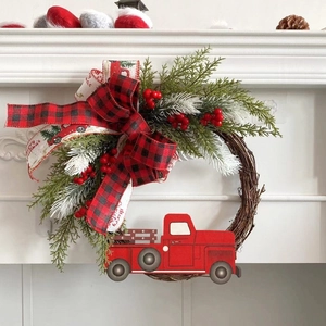Christmas wreath with red truck, cedar branches, and merry christmas bow on white fireplace