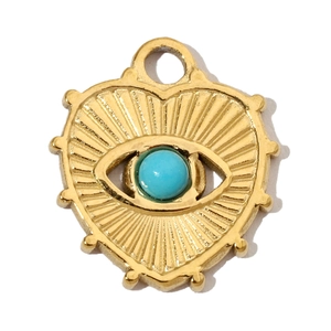 Detail of a heart-shaped gold steel pendant with evil eye motif and blue stone inlay