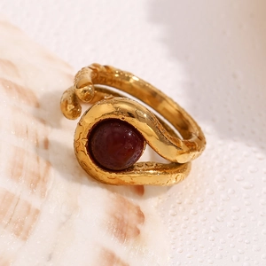 Detailed close-up of a gold-plated double-layer ring with textured finish and red bead