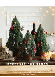 Detail of mini snowy Christmas trees with red berries and pine cones on wood base