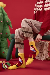 Detail showing plush coral fleece texture and cute Santa Claus embroidery on thick socks