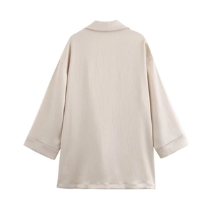Détail de la veste beige oversize montrant la texture plissée et la coupe décontractée