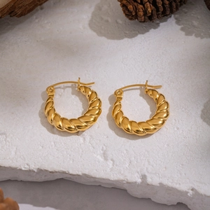 Classic 18K gold plated croissant twist hoop earrings for women on a stone background