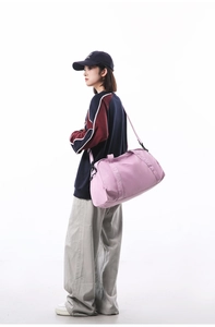 Professional model carrying a large capacity pink duffel bag for gym and travel use