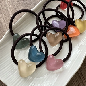 Detailed macro view of colorful translucent heart resin pendants on elastic hair ties