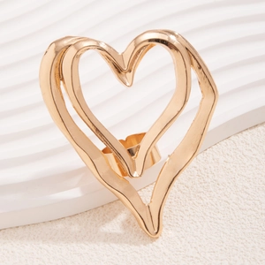 Close-up of golden hollow double heart ring with a polished metallic finish