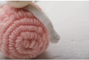 Macro shot of pink wool felt ornament showing detailed spiral crochet texture and fibers