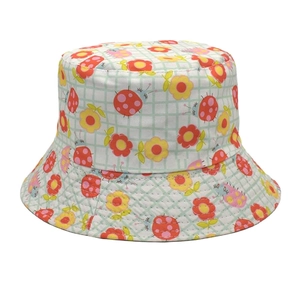 Detailed close-up of light green plaid bucket hat with ladybug and flower patterns