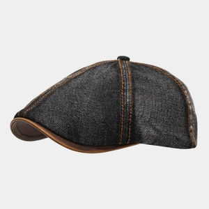 Detail of washed denim ivy cap featuring orange contrast stitching and leather brim edge