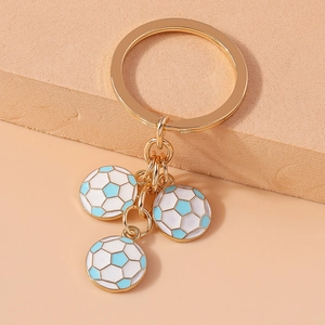 Close-up of golden metal keychain with three blue and white enamel football pendants