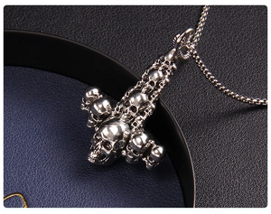 Macro shot of silver punk skull pendant with metallic chains on a dark textured surface