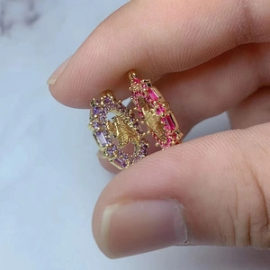 Goldene Ringe mit CD-Logo und rechteckigen Zirkonsteinen in Lila, Rosa und Rot
