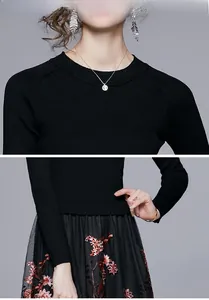 Detail of floral embroidery on black mesh skirt and ribbed knit sweater texture