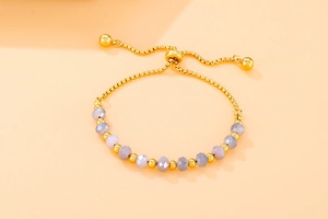 Detail of adjustable gold pearl chain bracelet with faceted light purple beads