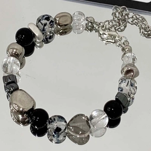 Macro shot of mixed beads bracelet featuring a grey crystal heart pendant and metal beads
