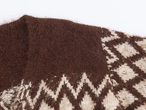 Dettaglio in primo piano della maglia a rombi marrone e beige in morbido mohair