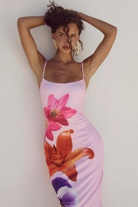 Close-up of pink bodycon maxi dress with red lily and purple pansy floral patterns