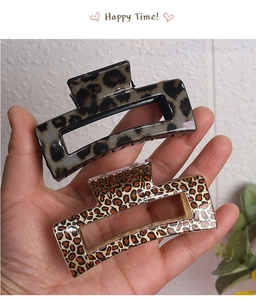 Close-up of leopard print square hair claws in dark and light patterns held by hand