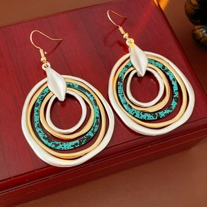 Detail of bohemian layered round drop earrings with turquoise gold and silver metallic rings