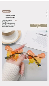 Close-up of rimless butterfly sunglasses with orange gradient lenses and gold metal details