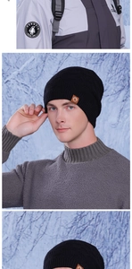 Detail view of black knit beanie with brown logo patch and thick fleece lining texture
