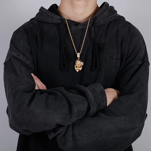 Close-up of gold hip hop lion head pendant with iced-out crown on a rope chain