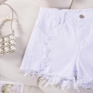 Dettaglio di pantaloncini in denim bianco con design strappato e bordi sfrangiati