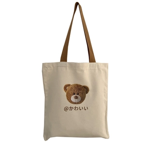 Minimalist canvas tote bag with brown bear print and shoulder straps on white background