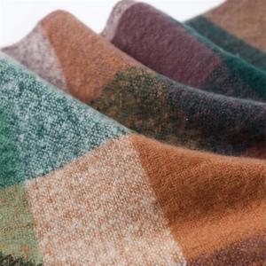 Close-up of soft cashmere-like scarf showing green and orange checkered wool texture
