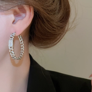 Close-up of 18k gold plated Cuban link hoop earrings with zircon pavé on a model