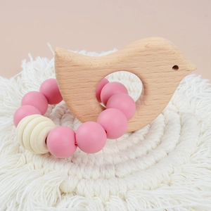 Baby teething bracelet with pink silicone beads and a beech wood bird shaped toy